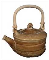 Ceramic teapot with a textured brown glaze and bamboo handle, showcasing handcrafted pottery design and artistry.