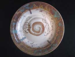 Ceramic bowl featuring a spiral design with glazes in earth tones, showcasing intricate detailing and a glossy finish.