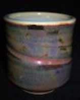 Ceramic cup featuring a glossy, multicolored glaze with subtle variations and a smooth finish, ideal for studio use.