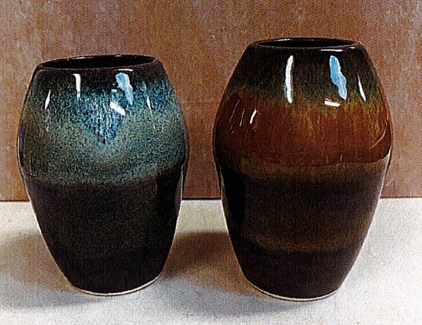 Two ceramic vases with glossy glazes in deep green and rich brown hues, showcasing gradient color effects.