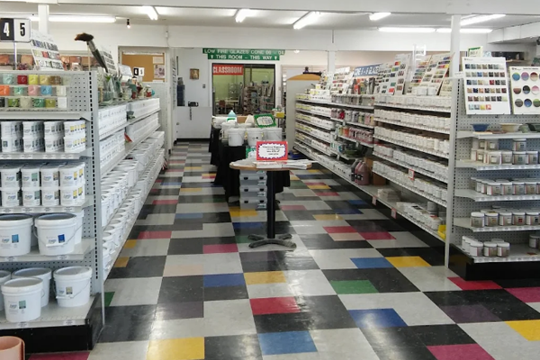 georgies-location-3 Colorful aisle in a ceramics supply store, showcasing shelves of pottery supplies, glazes, and tools for ceramic artists.