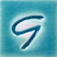 Glazed ceramic sample featuring a glossy turquoise background with a stylized blue letter G in the center.