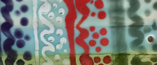 Colorful ceramic glaze sample showcasing bright blue, red, green, and purple patterns, ideal for decorative pottery projects.