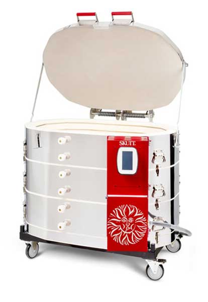 Skutt-kiln-KMT-1427-3″-PK SKUTT kiln with an open lid, designed for firing ceramics and pottery in a clay studio setting.