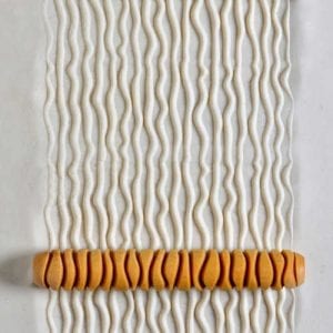Textured clay slab with raised wave patterns, showcasing decorative techniques for pottery at Georgies Ceramic & Clay Company.