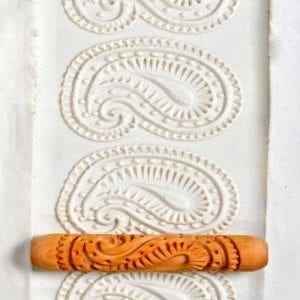 Decorative clay slab with an embossed design from a patterned rolling pin, showcasing intricate texture.