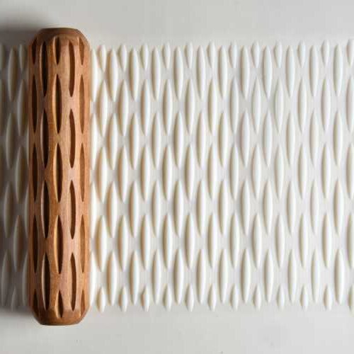 Textured clay surface created using a wooden rolling tool, designed for ceramic decoration and surface design.