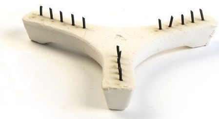 Ceramic kiln shelf support with three prongs and black pins, used for stacking pottery during firing at Georgies Ceramic & Clay Company.