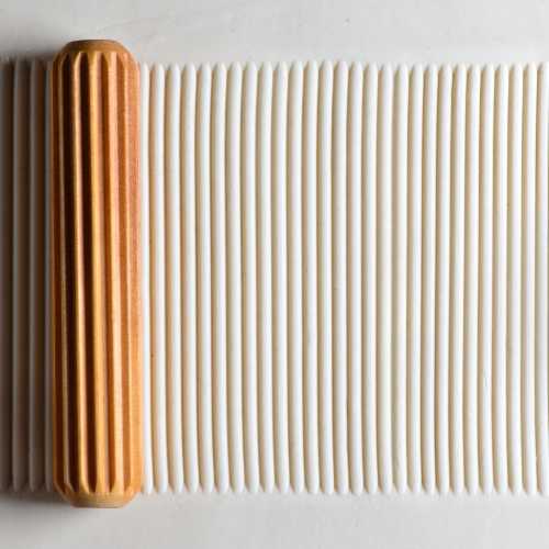 Textured white clay rolled flat with a ribbed wooden rolling pin, ideal for ceramics and pottery projects at Georgie's Ceramics.