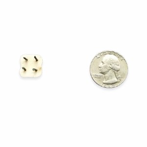 Close-up of a small, square ceramic piece with four prongs next to a quarter for size reference, ideal for kiln firing.