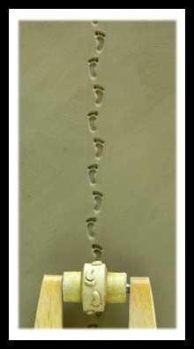 Footprint impressions on clay created with a decorative roller, showcasing texture for pottery design and sculpture.