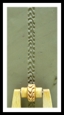 Clay texture created using a decorative rib tool, showcasing a wavy pattern carved into the clay surface.