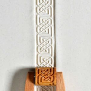 Celtic-patterned clay strip with a wooden handle, intended for pottery decoration or sculpting at Georgies Ceramic & Clay Company.
