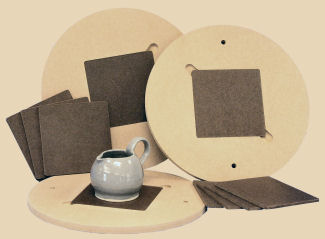 Ceramic trimming tools including a grey pottery mug, wooden batts, and circular batts for supporting clay wares during shaping.