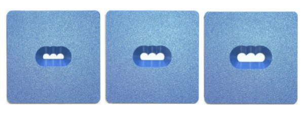 Three square blue ceramic test tiles with textured surfaces and cut-out shapes, used for glaze and firing experimentation.