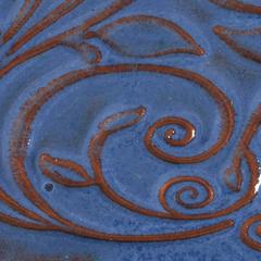 Blue ceramic surface with intricate brown floral designs, showcasing a glossy glaze finish typical of high-fired pottery.