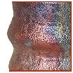 Close-up of a ceramic piece showcasing iridescent glazes with textured surfaces, ideal for decorative and functional pottery.