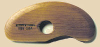 Wooden rib tool for shaping clay, marked STUMPERS TOOLS 1980 USA, used in pottery for smoothing and refining surfaces.