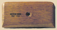 A wooden Kemper tool with a hole in the center, designed for sculpting and carving in ceramics and clay.