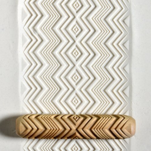 Textured white clay slab with a wood rolling pin featuring a zigzag pattern, used for ceramic decorating techniques.