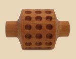 Wooden texturing roller tool with perforations for adding designs to clay surfaces in pottery and ceramics.