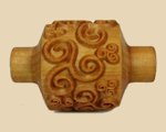 Carved wooden texture tool featuring intricate swirl patterns for applying designs in pottery and ceramics.