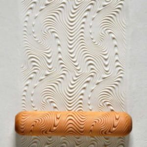 Textured clay surface created by a wavy rolling pin, ideal for ceramic decoration and artistic design projects.