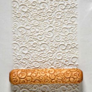 Textured rolling pin creating swirled patterns on white clay, ideal for ceramic decorating at Georgies Ceramic & Clay Company.