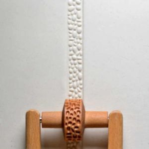 Textured clay pattern created with a wooden clay roller, showcasing a unique relief design for pottery decoration.