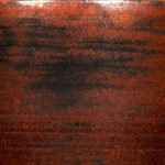 Deep red-brown ceramic glaze with subtle texture and dark speckles, ideal for pottery and decorative pieces.
