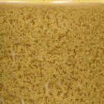 Golden yellow ceramic glaze with a textured, speckled finish, ideal for adding unique color to pottery and sculptures.