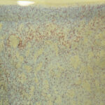 Speckled yellow and blue ceramic glaze sample showcasing unique texture and color variations for clay artwork.