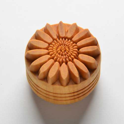 Wooden pottery tool with a sunflowers design, used for decorating clay surfaces in ceramics and pottery projects.