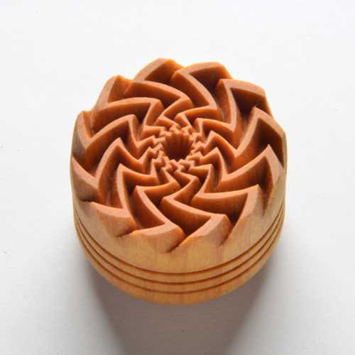 Wooden clay trim tool with a spiral design, used for decorative finishing in pottery and ceramics. Ideal for texture application.