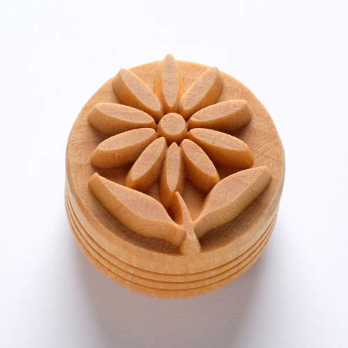 Floral texture stamp made from clay, featuring a flower design with leaves, ideal for pottery decoration and sculpture.