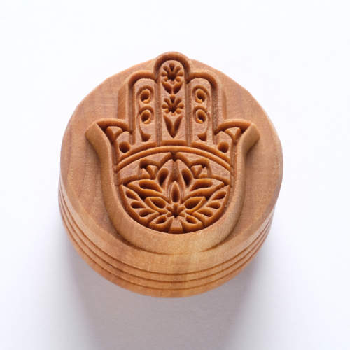Carved wooden stamp featuring a hamsa design, ideal for decorating pottery and ceramics at Georgies Ceramic & Clay Company.