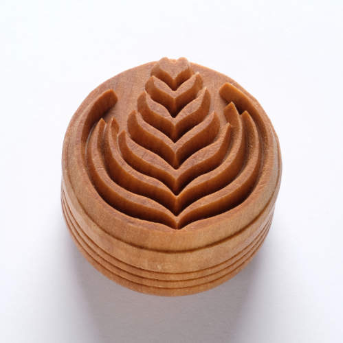 Carved clay texture tool for decorating pottery with a leaf pattern, ideal for creating intricate designs in ceramics.
