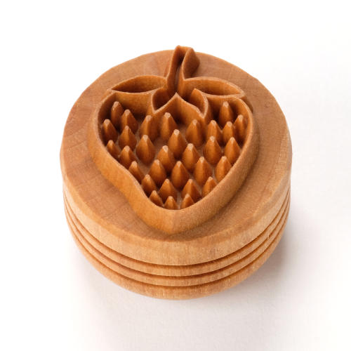 Wooden strawberry stamp used for decorating clay surfaces, ideal for pottery and ceramics projects.