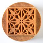 Textured clay stamp with a geometric star pattern, used for impressing designs on pottery and ceramics.