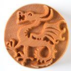 Ceramic stamp featuring a dragon design, ideal for creating decorative textures on pottery and clay projects.
