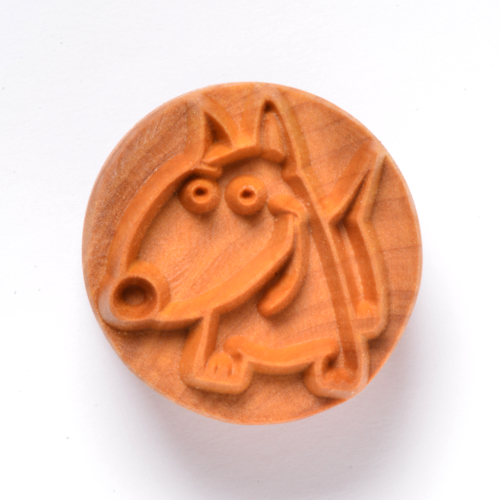 Carved clay stamp featuring a cartoon dog design, ideal for decorating pottery and ceramics.