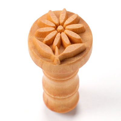 Wooden carving tool with a floral design, used for decorating pottery and ceramics at Georgies Ceramic & Clay Company.