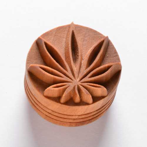Carved clay stamp featuring a leaf design, ideal for decorating pottery and ceramics. Perfect for texture and detail work.