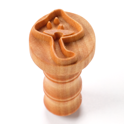 Carved wooden stamp featuring a flower design, ideal for decorating pottery or clay projects in ceramics.