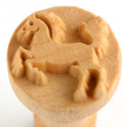A carved wooden pottery stamp featuring a horse design, ideal for decorating ceramic pieces and clay projects.