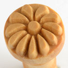 Ceramic stamping tool with a floral design, used for decorating clay pottery and sculptures at Georgies Ceramic & Clay Company.