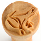 Ceramic frog stamp tool featuring an intricately carved frog design, ideal for pressing into clay projects.