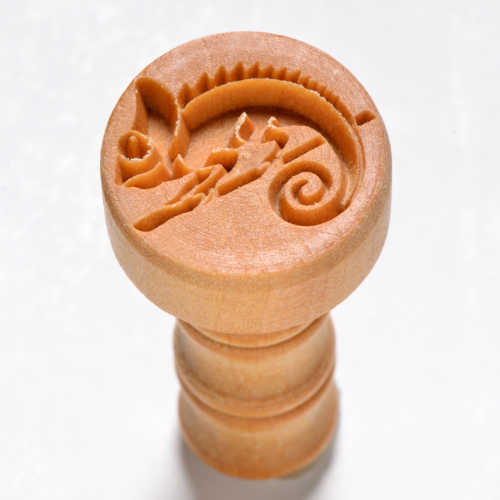 Carved wooden pottery stamp with a chameleon design for decorating ceramics and clay projects.