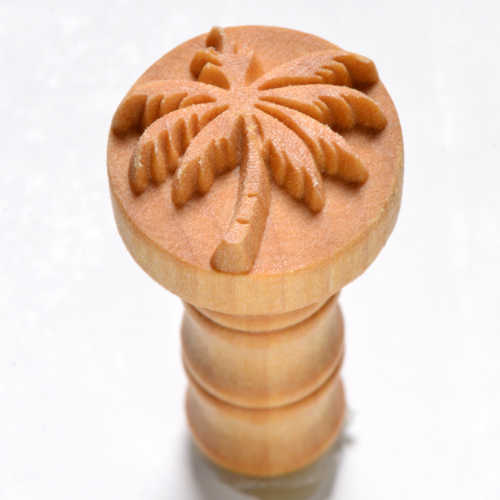 Wooden pottery stamp featuring a palm tree design, used for decorating ceramics and clay projects at Georgie's Ceramic & Clay Company.