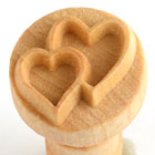Wooden heart-shaped stamp for decorating ceramics, ideal for creating textured designs on clay surfaces.
